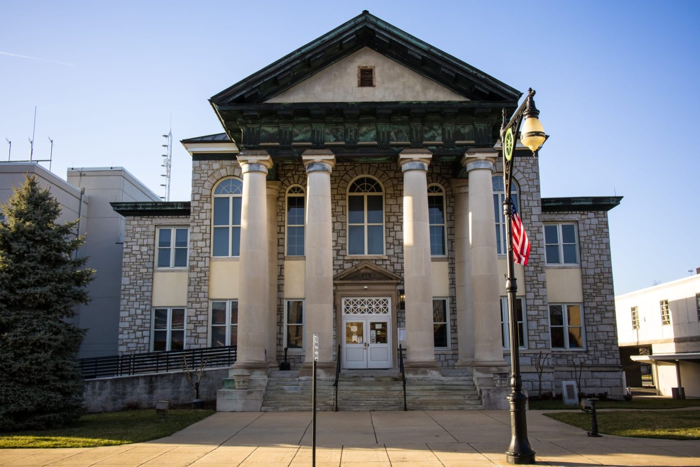 Stone and brick Alleghany County Courthouse in Covington, Virginia with columns.