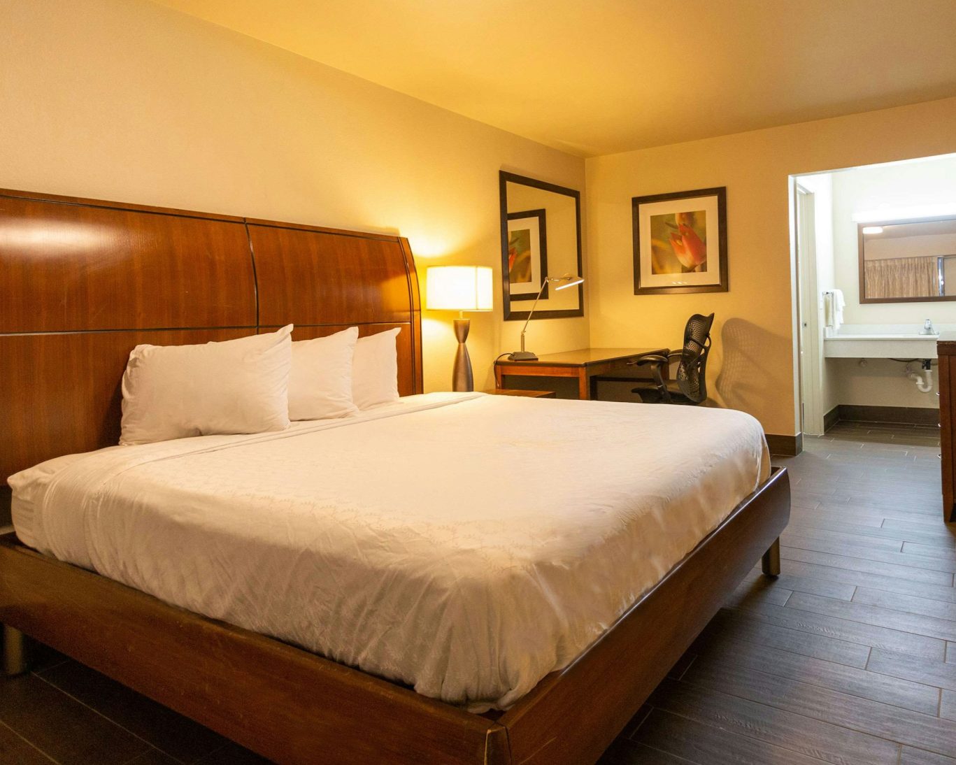 Spacious hotel room with king-size bed, work desk, and modern furnishings for business or leisure stays.