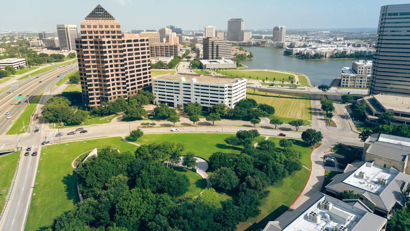 Aerial view of urban business district in Irving, Texas with office buildings and lake.