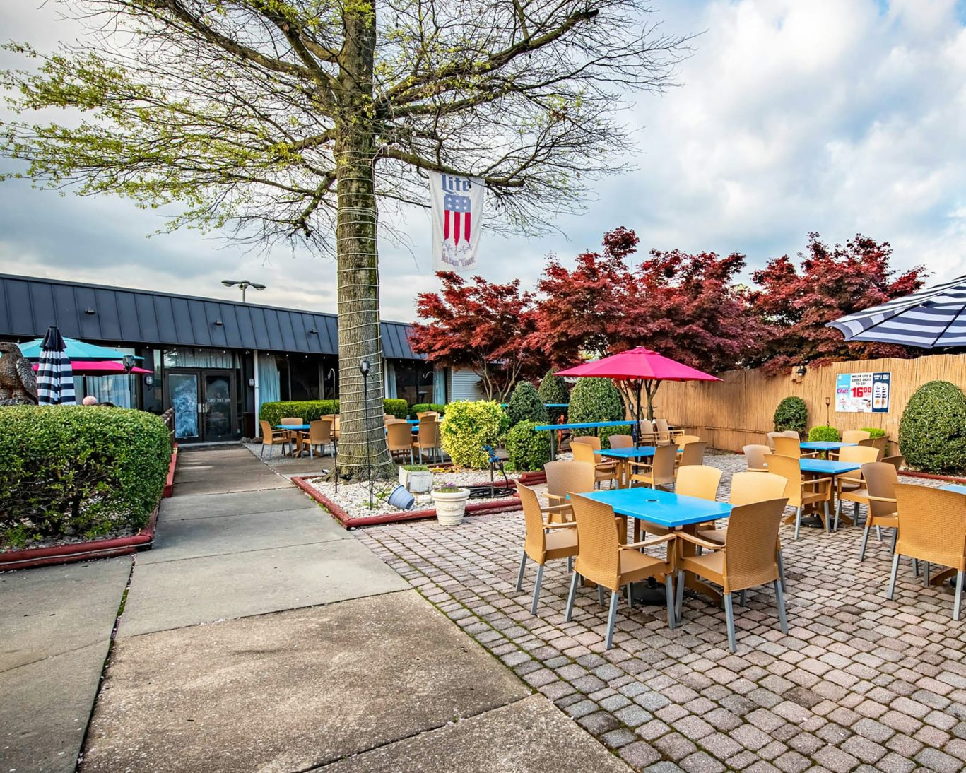 Colorful outdoor dining patio with umbrellas and trees at a casual restaurant in Pennsylvania.