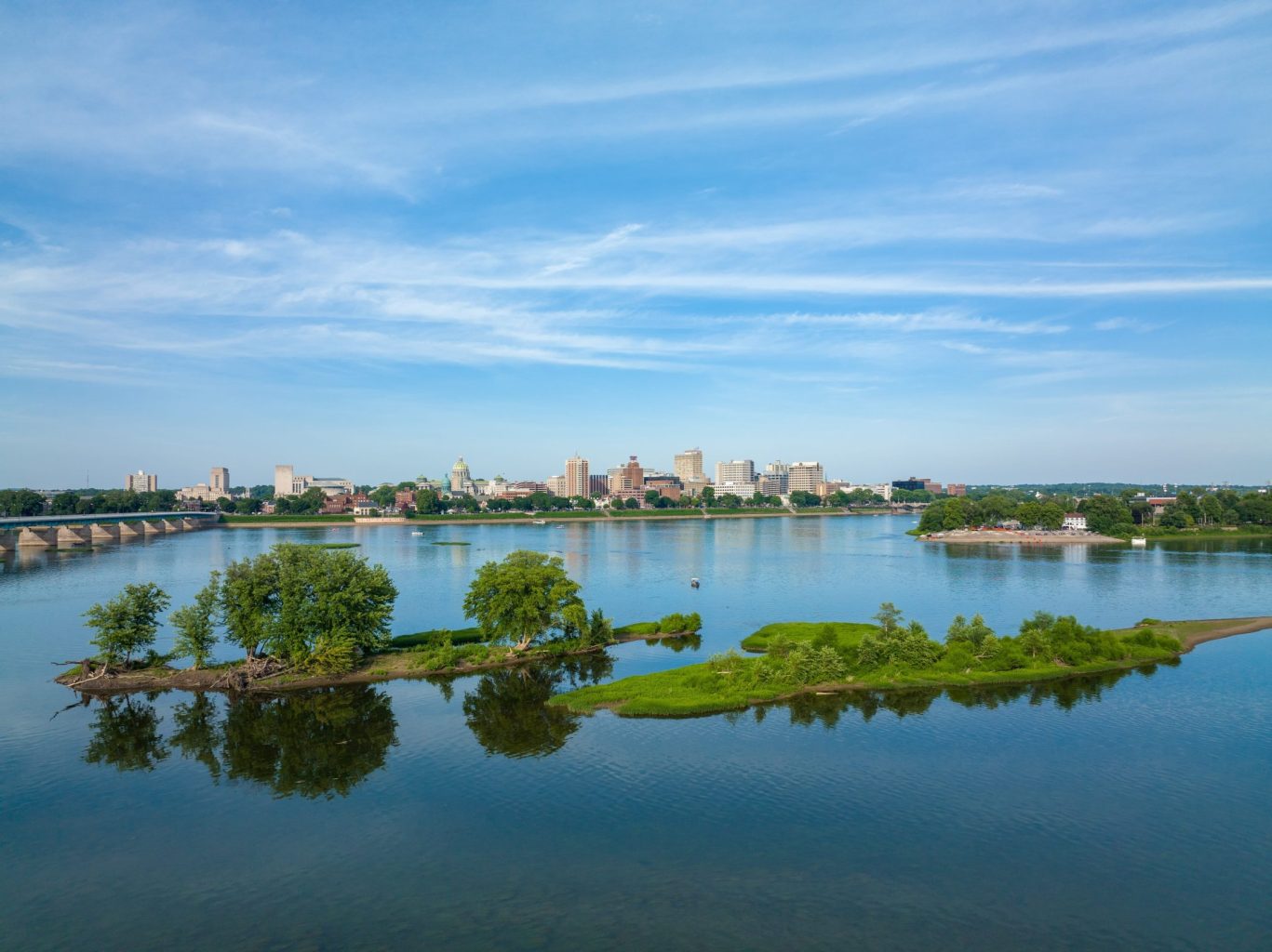 Skyline of Harrisburg, Pennsylvania reflected in the Susquehanna River on a clear summer day.