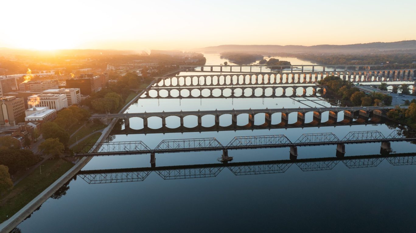 Sunset over Susquehanna River with historic railroad and stone arch bridges in Harrisburg, Pennsylvania.