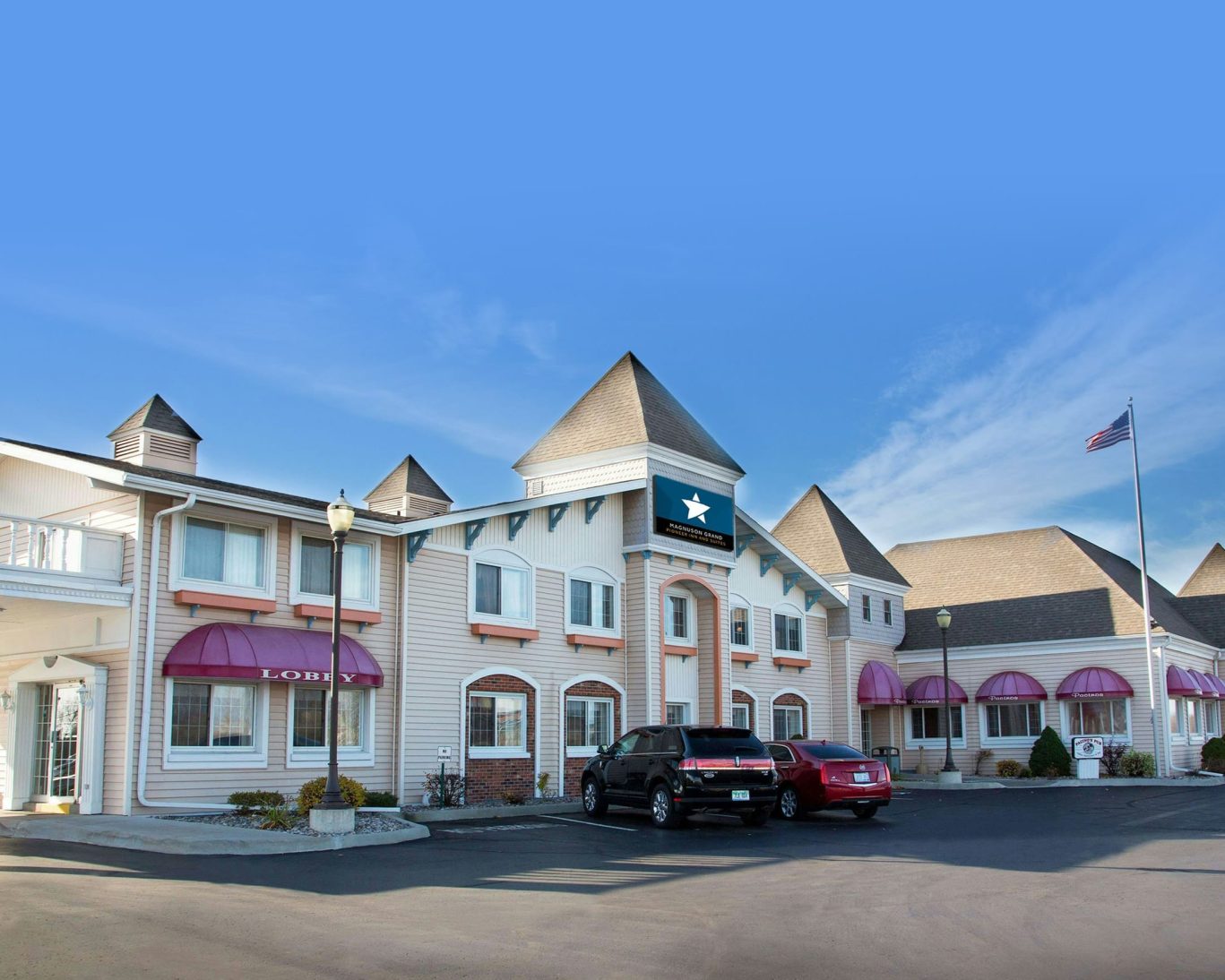Charming exterior of Jamestown Grand hotel with turret-style architecture and convenient parking.