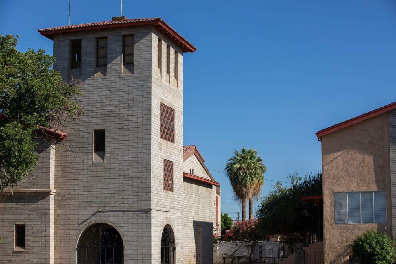 Historic brick building with red-tile roof in Blythe, California, under a clear blue sky.