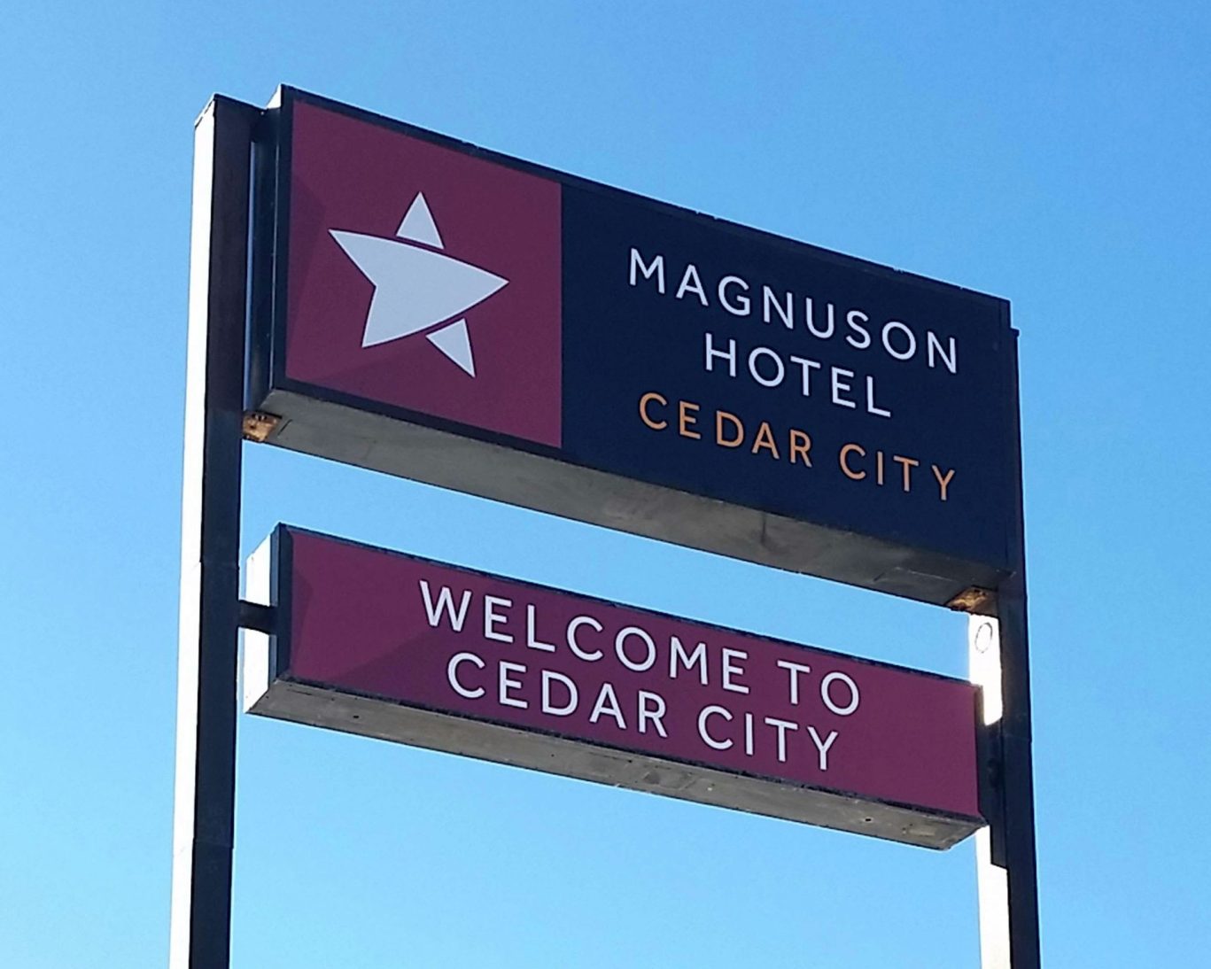 Magnuson Hotel Cedar City welcome sign against a blue sky.