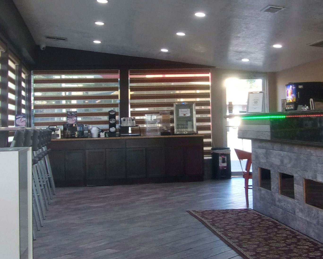 Magnuson Hotel lounge with coffee and drinks station in a modern rustic setting.