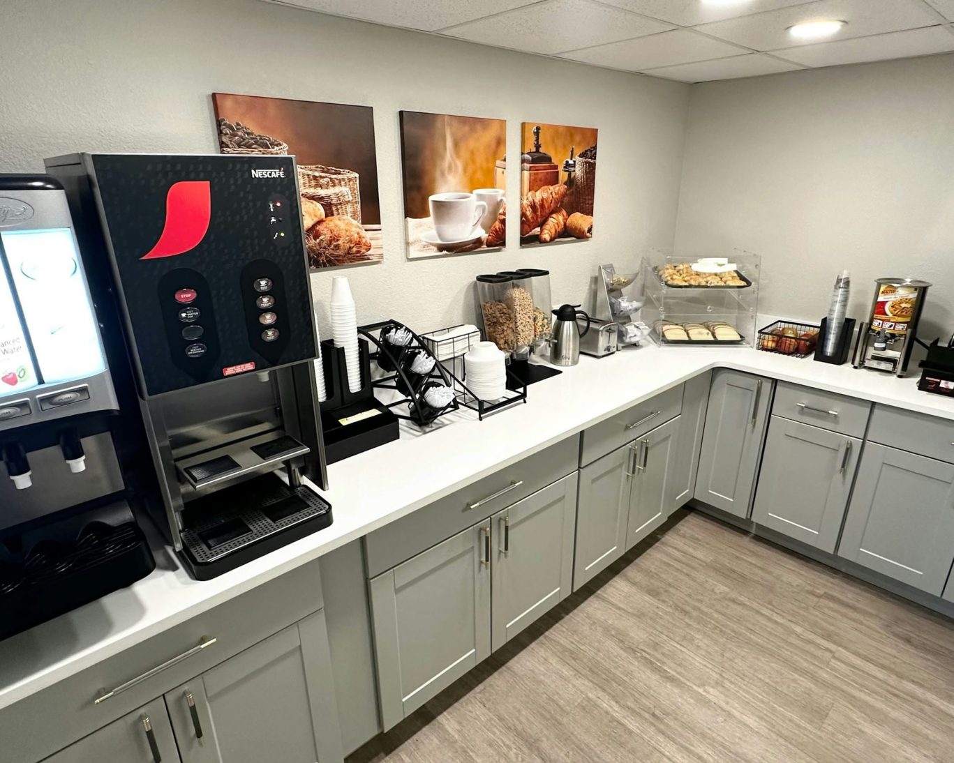 Self-serve breakfast bar with coffee, cereal, and pastries at Magnuson Hotel Detroit.