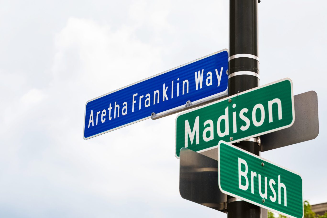 Street signs for Aretha Franklin Way, Madison, and Brush in Detroit, Michigan.