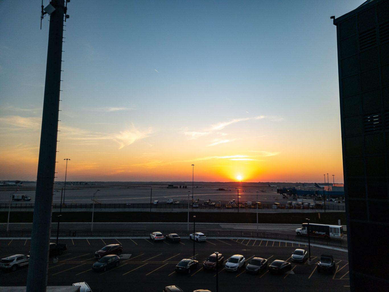 Detroit Metro Airport runway and parking lot at sunset.