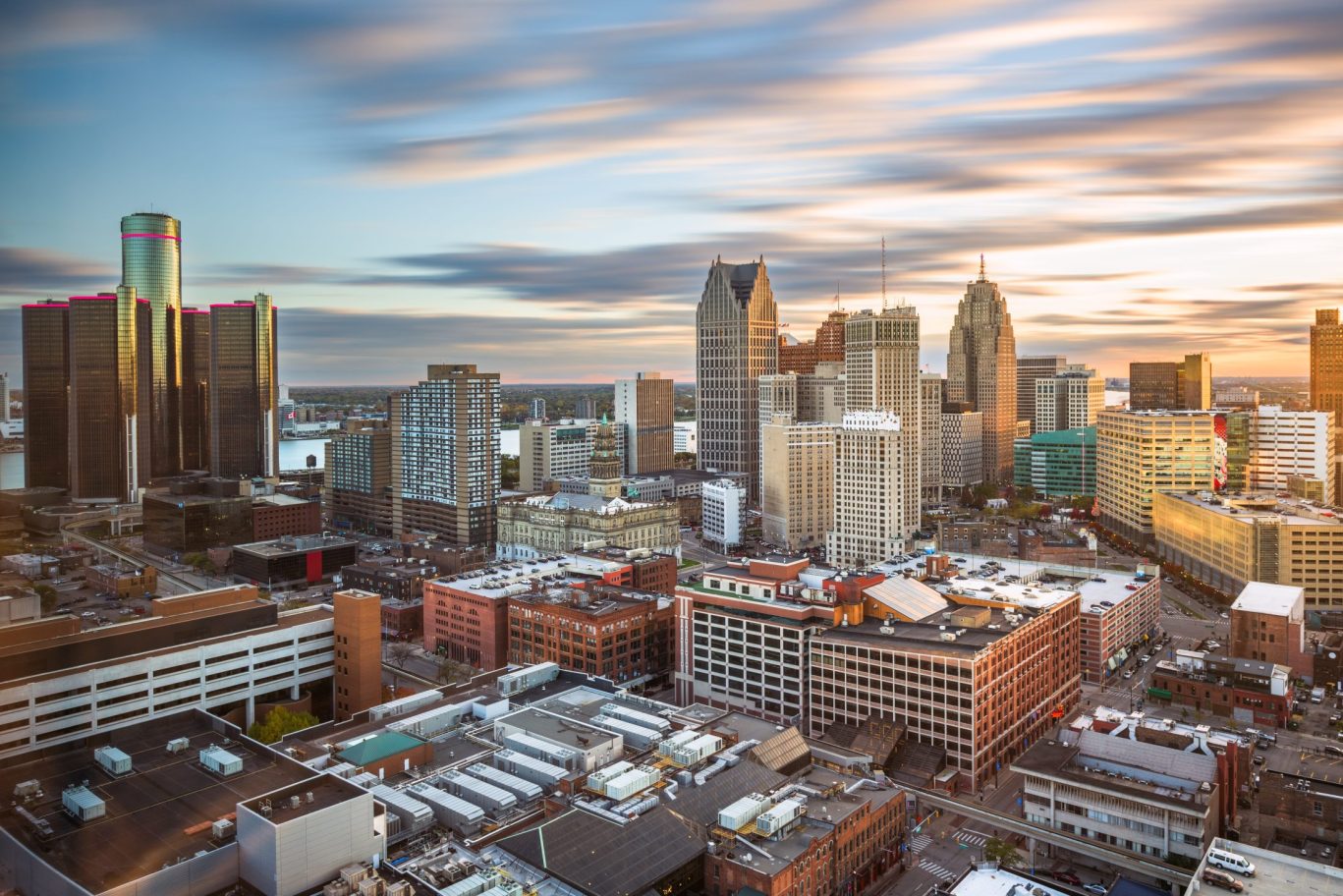 Aerial view of Detroit skyline during sunset with skyscrapers and river in background.