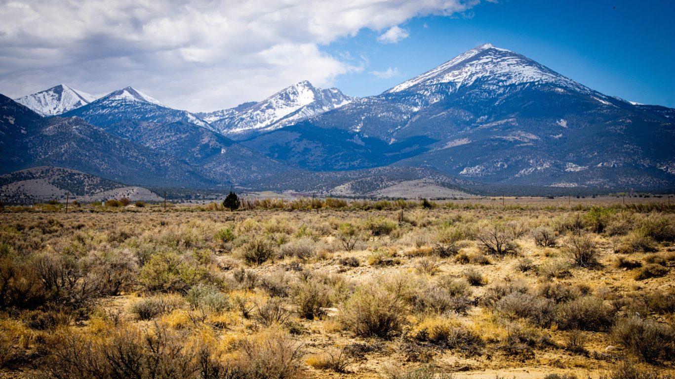 Majestic snow-capped mountain peaks under a dramatic sky near Ely, Nevada.