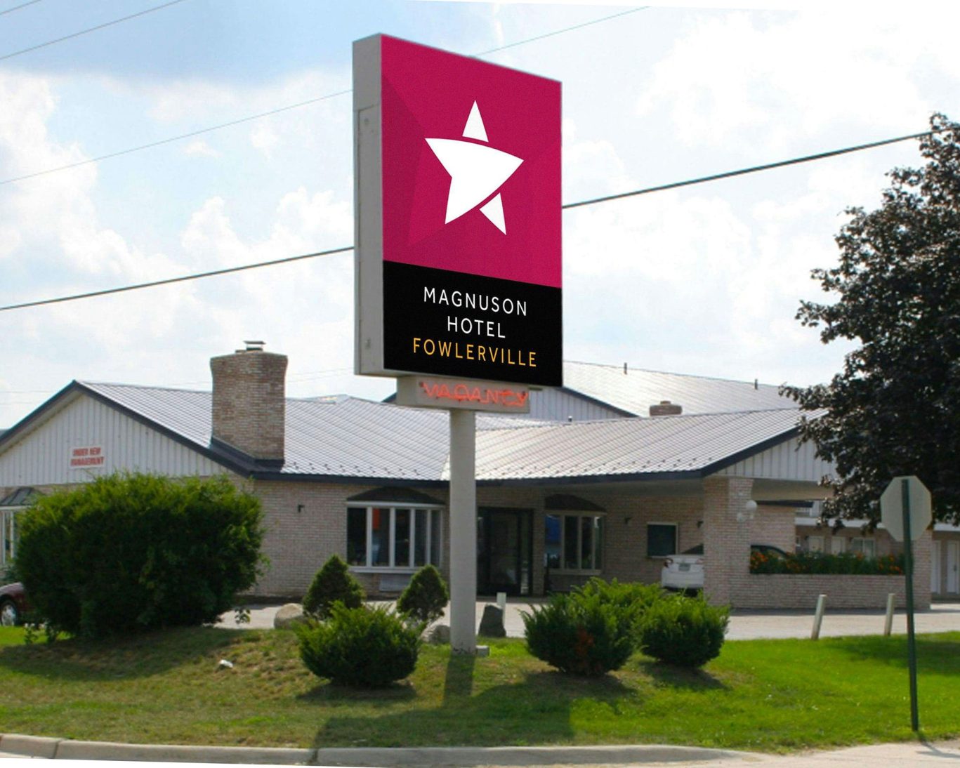 Exterior view of Magnuson Hotel Fowlerville with branded signage near the main entrance.