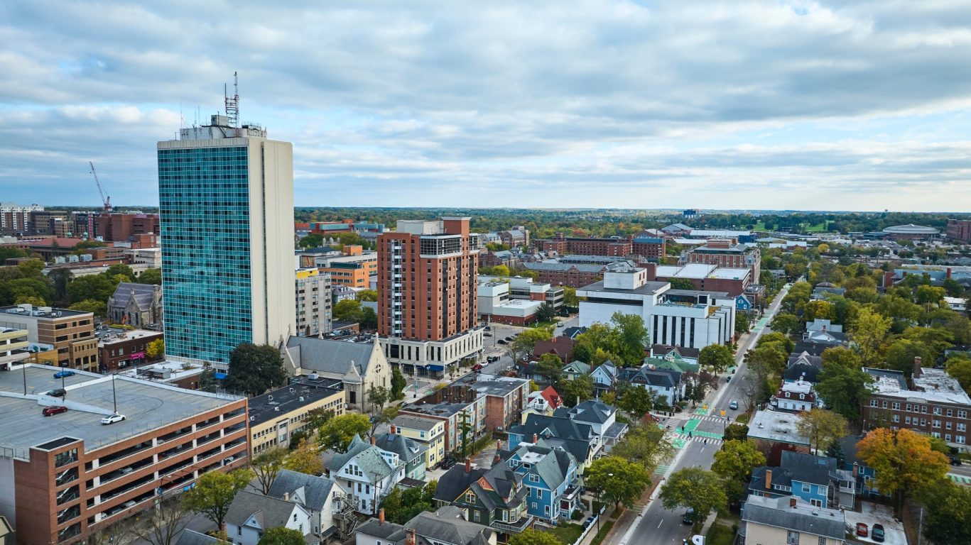 Aerial skyline view of downtown Lansing, Michigan with modern buildings and urban neighborhoods.