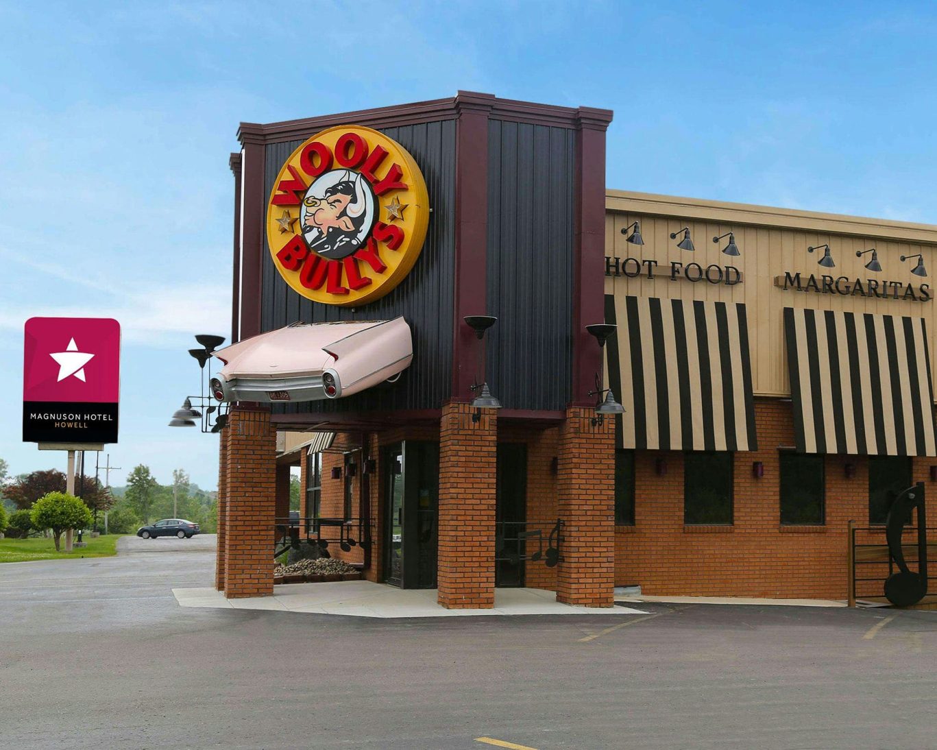 Wooly Bully's restaurant exterior near Magnuson Hotel Howell featuring bold signage and classic car decor.