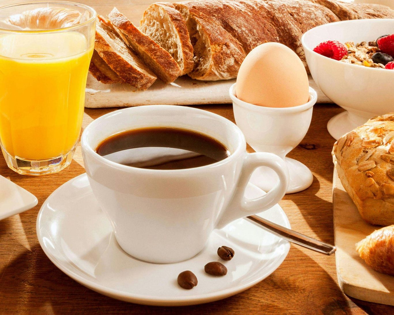 Healthy continental breakfast with croissants, fresh fruit, granola, cereal, juice, and coffee.