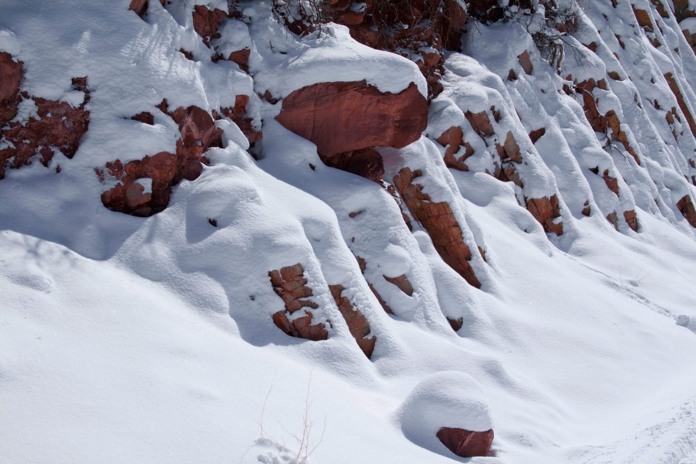 Snow-covered red rock formations during wint.er near Magnuson Hotel in a scenic natural location.