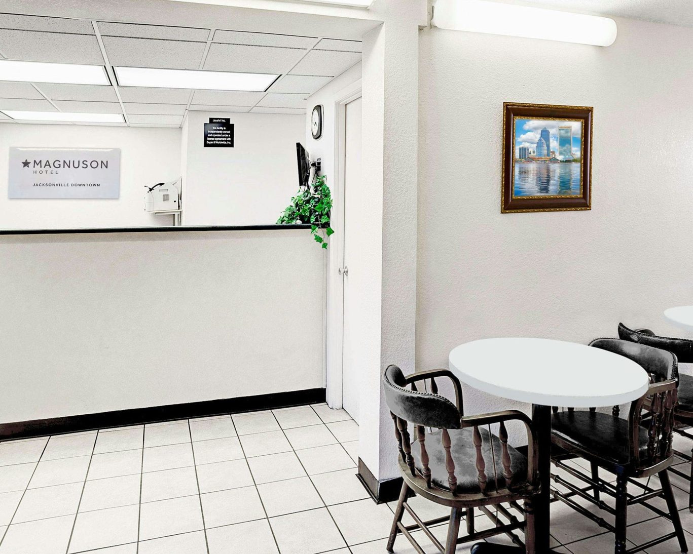 Magnuson Hotel Jacksonville Downtown front desk and guest seating area with bright white interior.