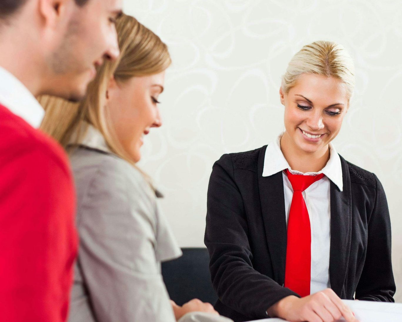 Hotel front desk agent assisting couple with check-in at Magnuson Hotel Jacksonville Downtown.