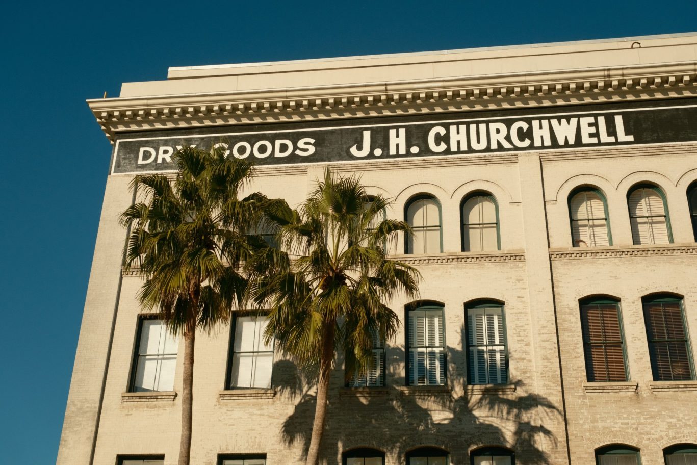 Historic J.H. Churchwell dry goods building with palm trees in downtown Jacksonville.
