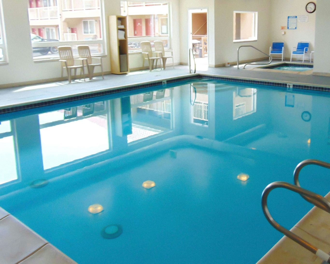 Indoor swimming pool with poolside seating at Magnuson Hotel Manitou Springs.