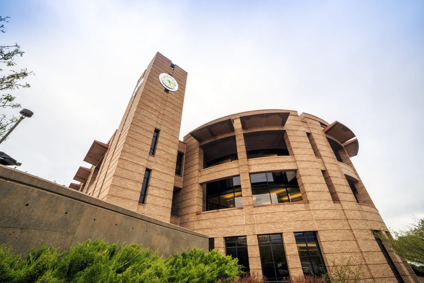 Contemporary brick academic building with clock tower and curved architecture in Colorado Springs.