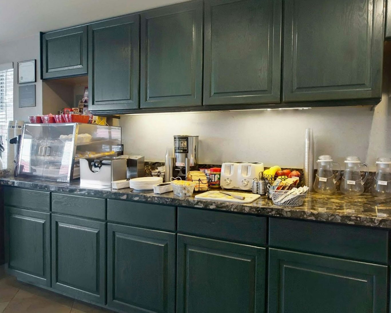 Hotel breakfast buffet with cereal, fruit, bread, and coffee station at Magnuson Hotel.