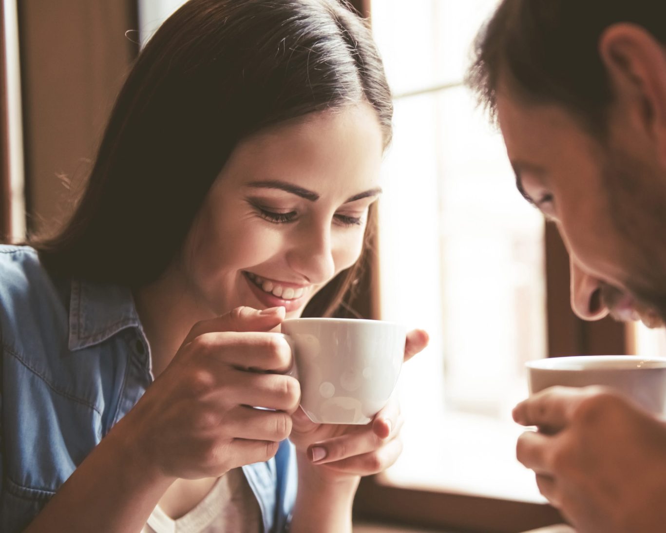 Couple enjoying coffee together in a cozy indoor setting.