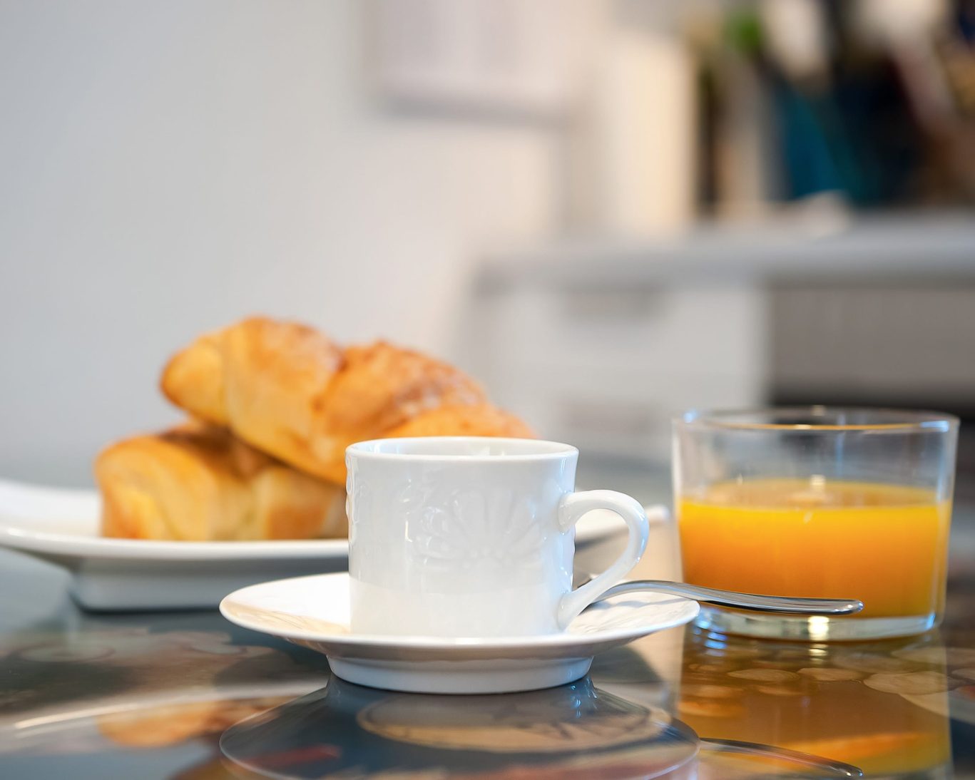 Continental breakfast with croissants, orange juice, and coffee.