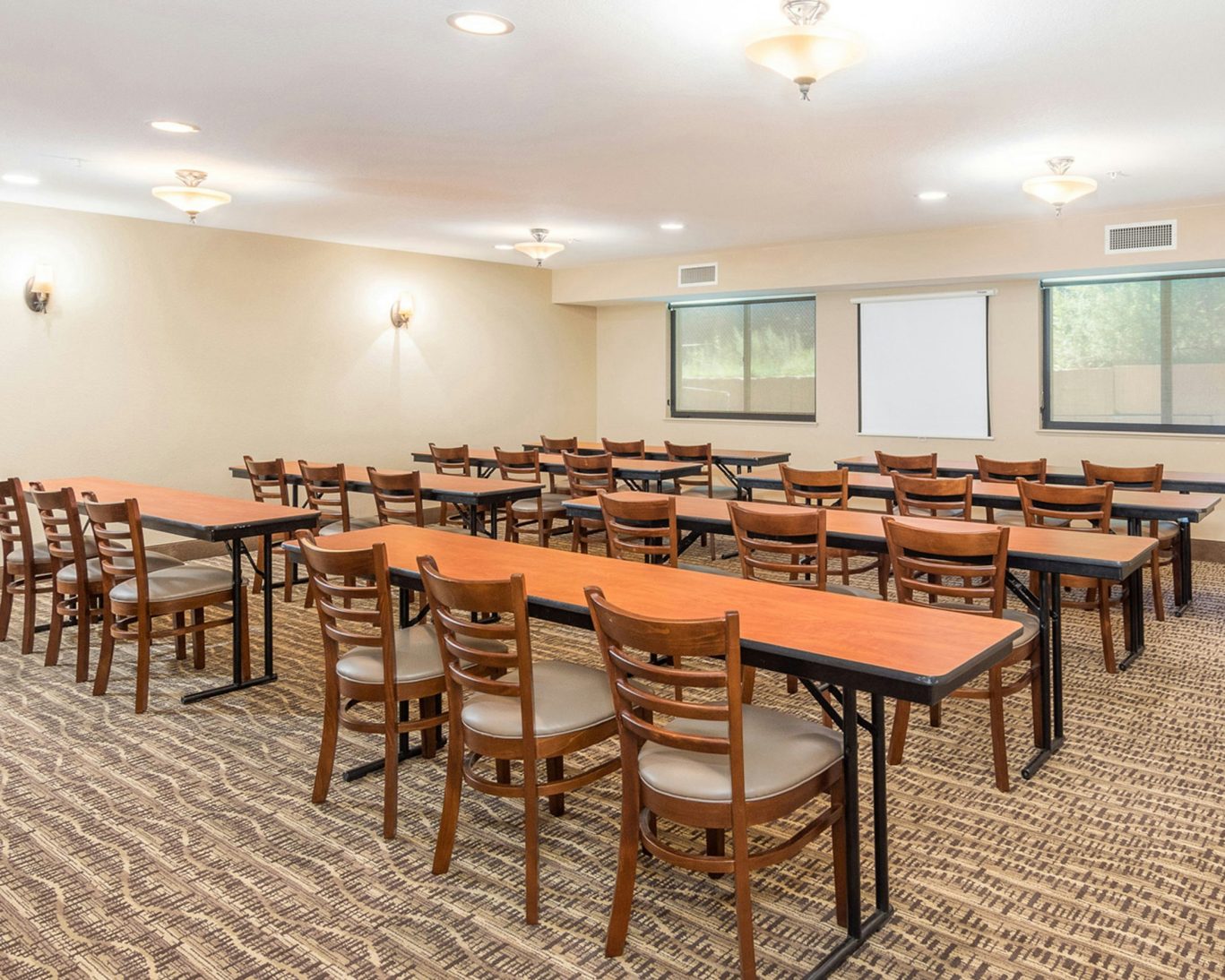 Spacious hotel meeting room with conference seating and presentation screen in Manitou Springs Colorado.