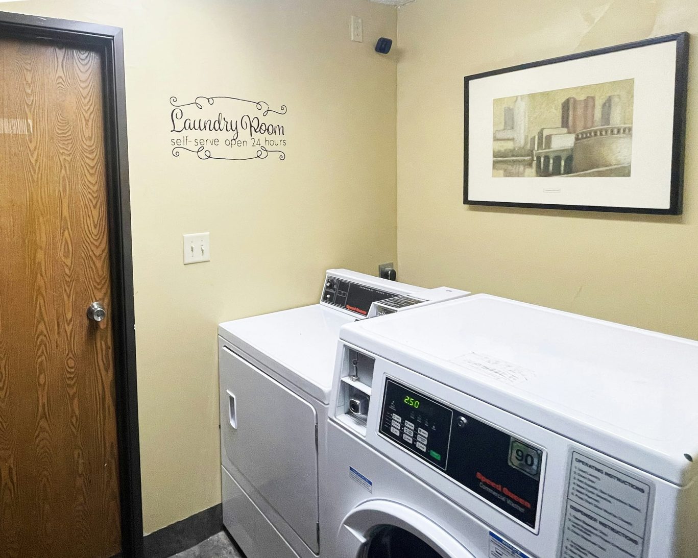 Self-serve laundry room at Magnuson Hotel Fort Wayne North with washer and dryer.