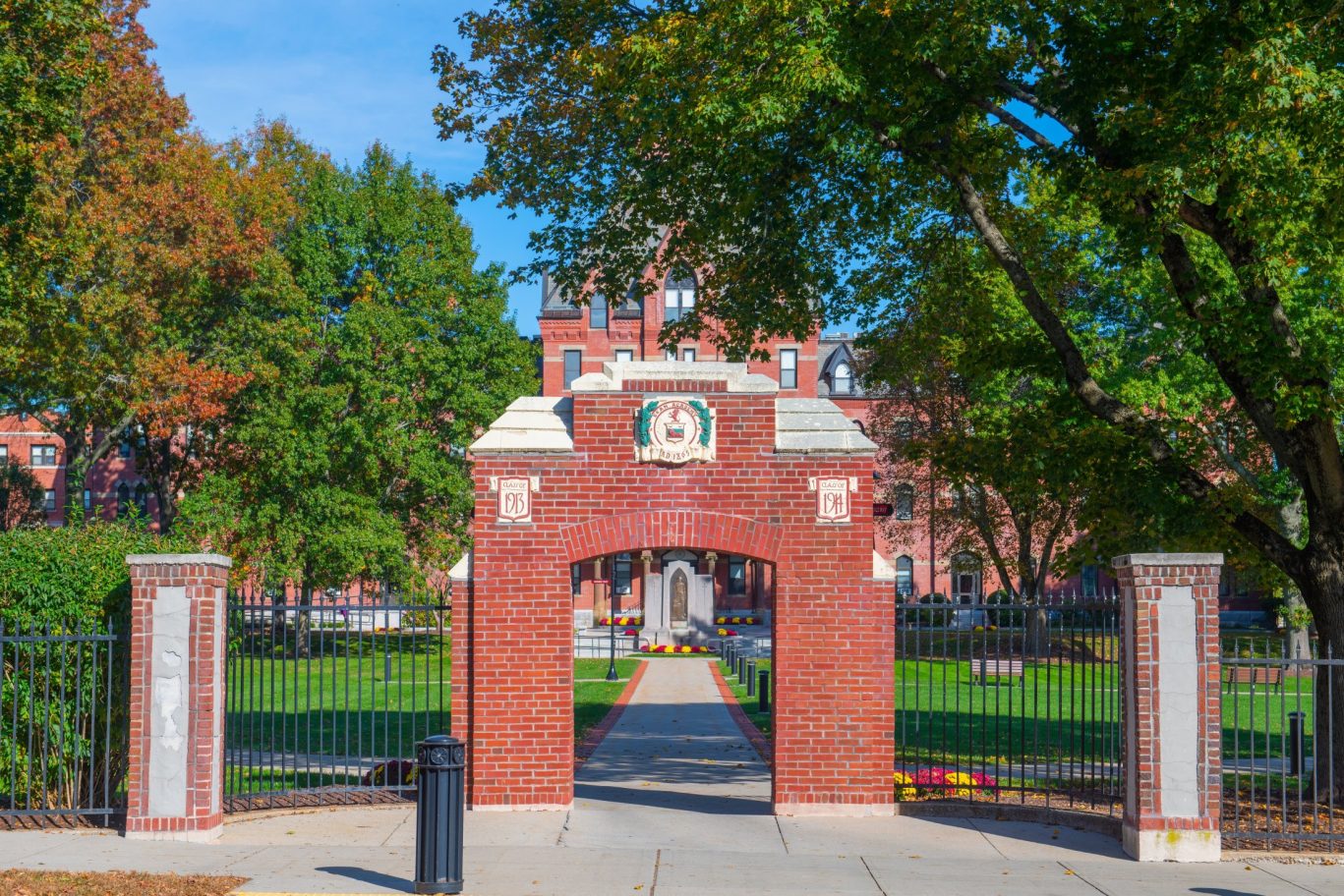 Brick arch entrance to Clark Atlanta University campus surrounded by trees and greenery.