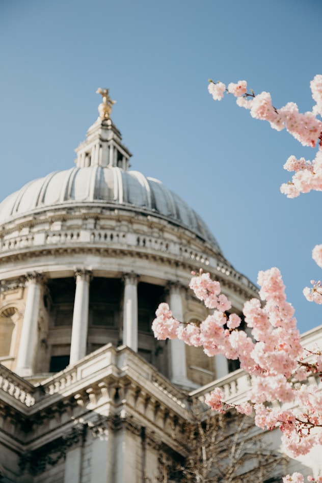 St. Paul's Cathedral in London, England, showcasing its iconic dome and historic architecture against a clear blue sky.