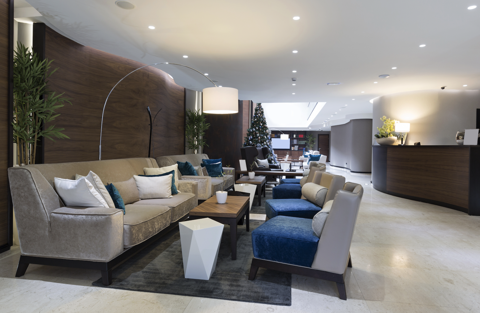 Modern hotel lobby featuring a reception desk and comfortable couches for guests to relax.
