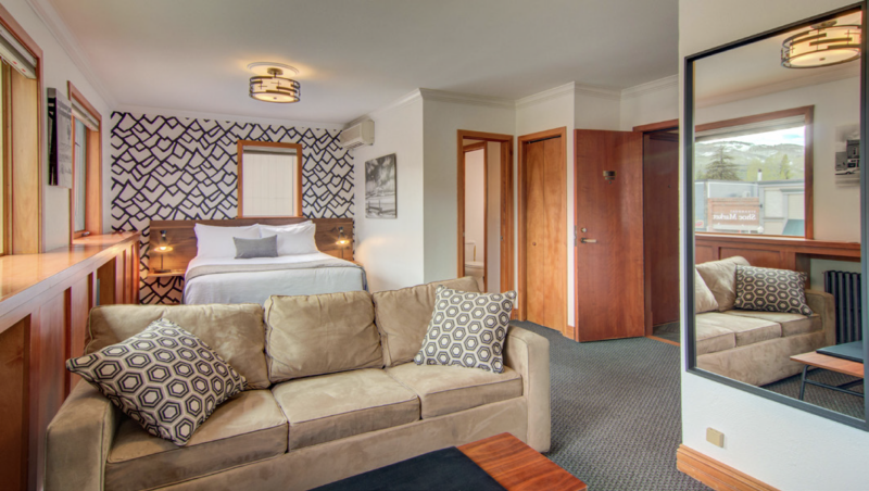 Cozy hotel suite featuring a comfortable sofa, bed, and stylish modern decor.