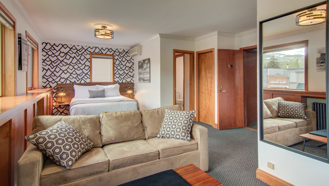 Cozy hotel suite featuring a comfortable sofa, bed, and stylish modern decor.