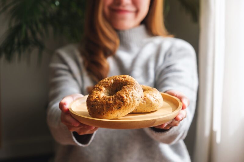 Woman serving homemade bagels on a plate